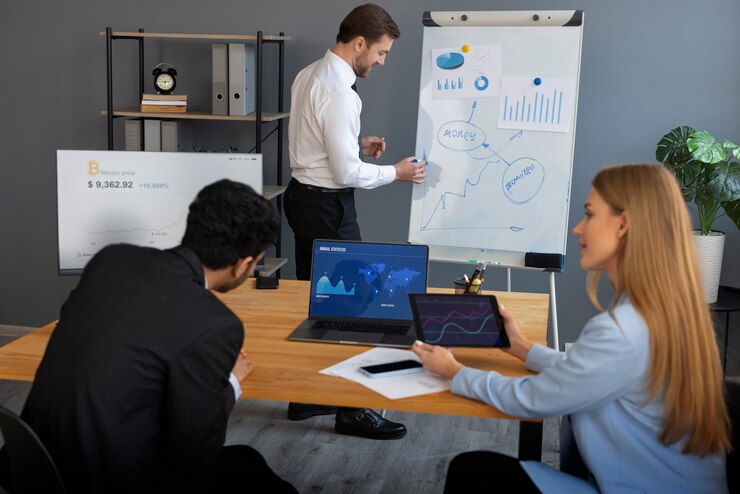 Team of marketing consultants analyzing data and business growth strategies using charts, graphs, and digital dashboards in a modern office setting.