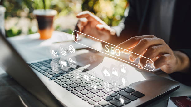 Hands typing on a laptop with virtual SEO icons, representing search engine optimization strategy and digital marketing tools.